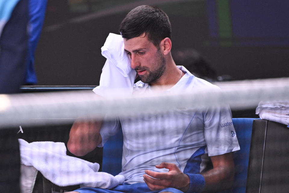 Novak Djokovic wipes his face.