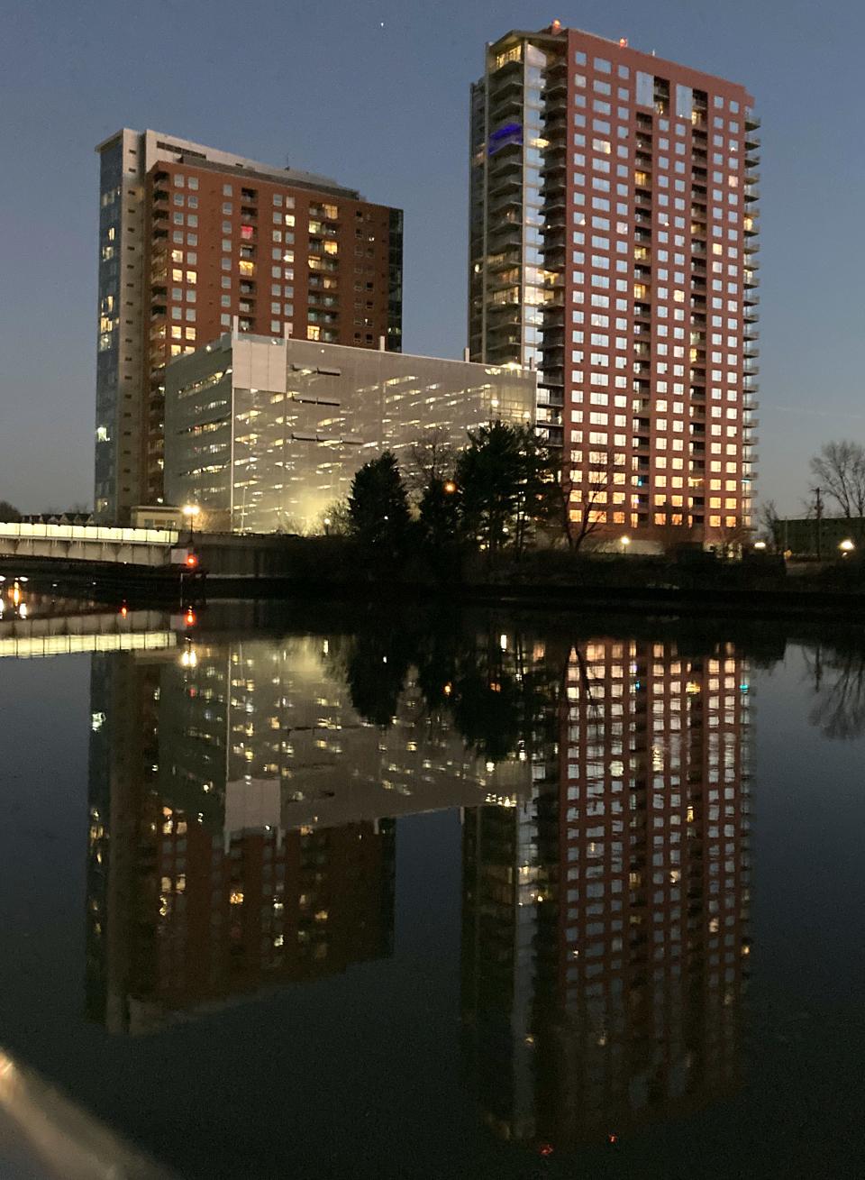 Sister residential towers in Wilmington – the Residences at Christina Landing, left, and the River Tower at Christina Landing – glow in early evening light over the Christina River in 2023.