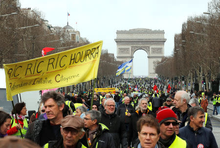 Protesters wearing yellow vests walk down the Champs Elysees during a demonstration by the "yellow vests" movement in Paris, France, March 9, 2019. REUTERS/Philippe Wojazer