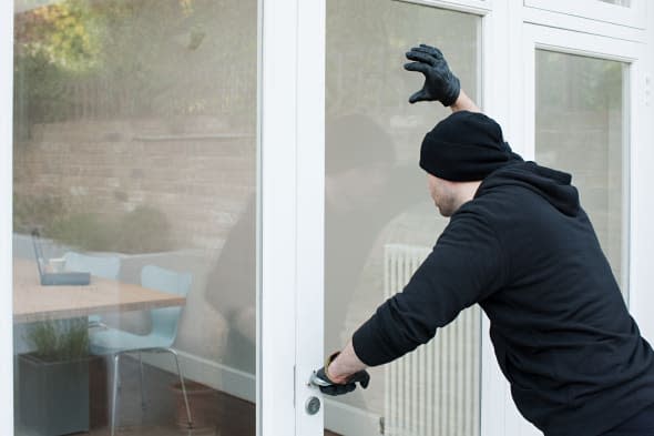 Burglar looking at laptop through window