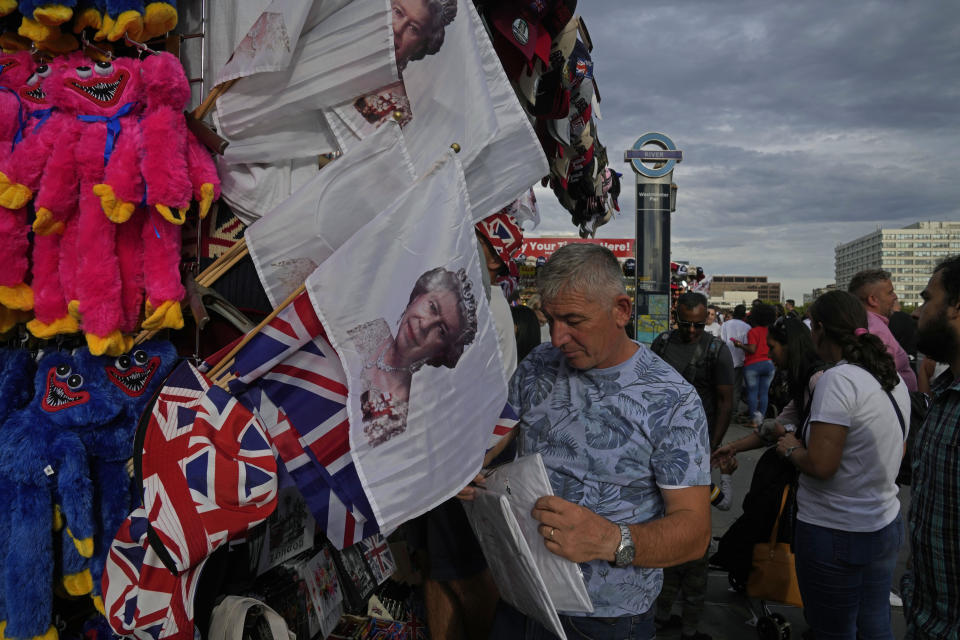 Flags printed with picture of Queen Elizabeth II are displayed for sale at a gift shop in London, Monday, Sept. 12, 2022. Just days after the death of Queen Elizabeth II, unofficial souvenirs have rolled out at royal-themed gift shops in London and online marketplaces like Amazon and Etsy. (AP Photo/Kin Cheung)