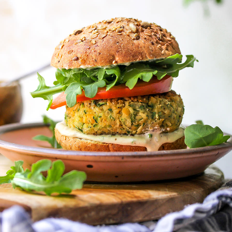 <p>This vegan burger recipe is one you'll want to make again and again. Savory chickpea and zucchini patties are topped with a creamy, herb-flecked tahini ranch sauce, juicy tomato slices and peppery arugula for a satisfying and healthy homemade veggie burger. Serve them on buns or stuff them in pitas. We recommend making extra sauce--it's a great dip for veggie sticks and, thinned with a little water, it makes a wonderful salad dressing. <a href="https://www.eatingwell.com/recipe/273894/zucchini-chickpea-veggie-burgers-with-tahini-ranch-sauce/" rel="nofollow noopener" target="_blank" data-ylk="slk:View Recipe" class="link ">View Recipe</a></p>
