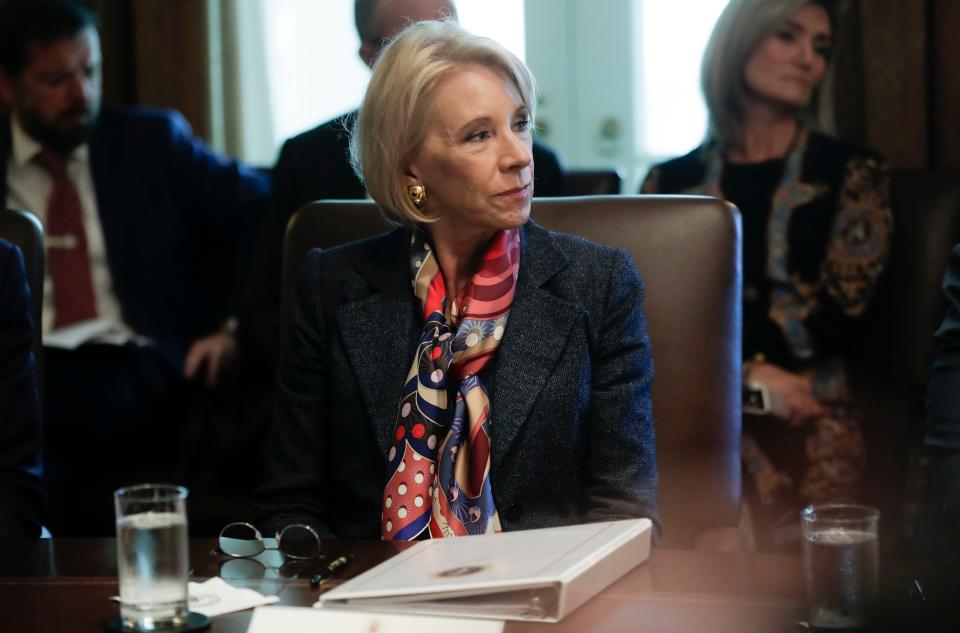 Education Secretary Betsy DeVos listens to President Donald Trump during a Cabinet meeting in 2019. The Education Department says colleges are unnecessarily delaying payments to students.