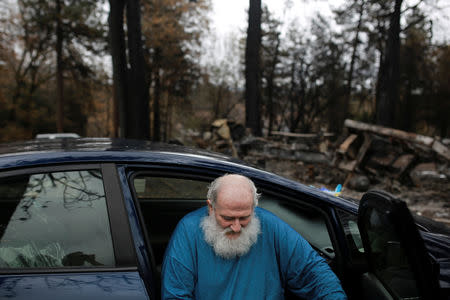 Stanley Miniszewski Sr. sits in his car next to the remains of his RV after returning for the first time since the Camp Fire forced him to evacuate at Pine Ridge Park in Paradise, California, U.S. November 22, 2018. REUTERS/Elijah Nouvelage