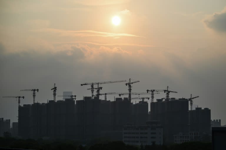 Buildings under construction are seen during sunset in Shanghai on September 6, 2024. (Hector RETAMAL)