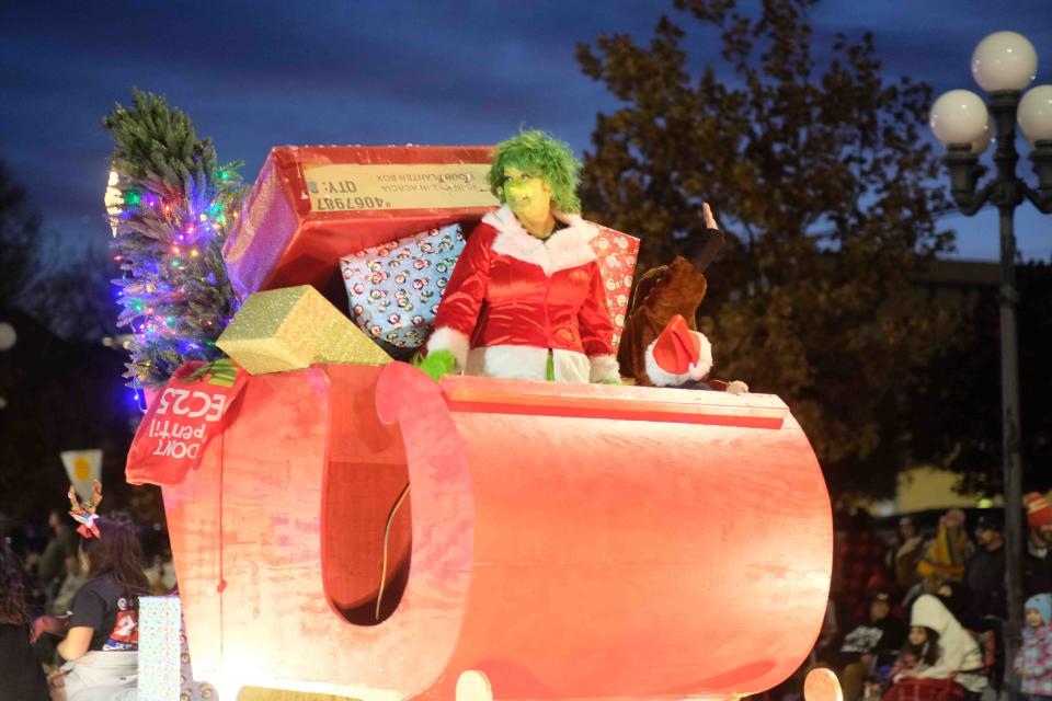 Lady Grinch rides Santa's sleigh down Polk Street Friday Night during the  annual Center City Electric Light Parade  in downtown Amarillo.