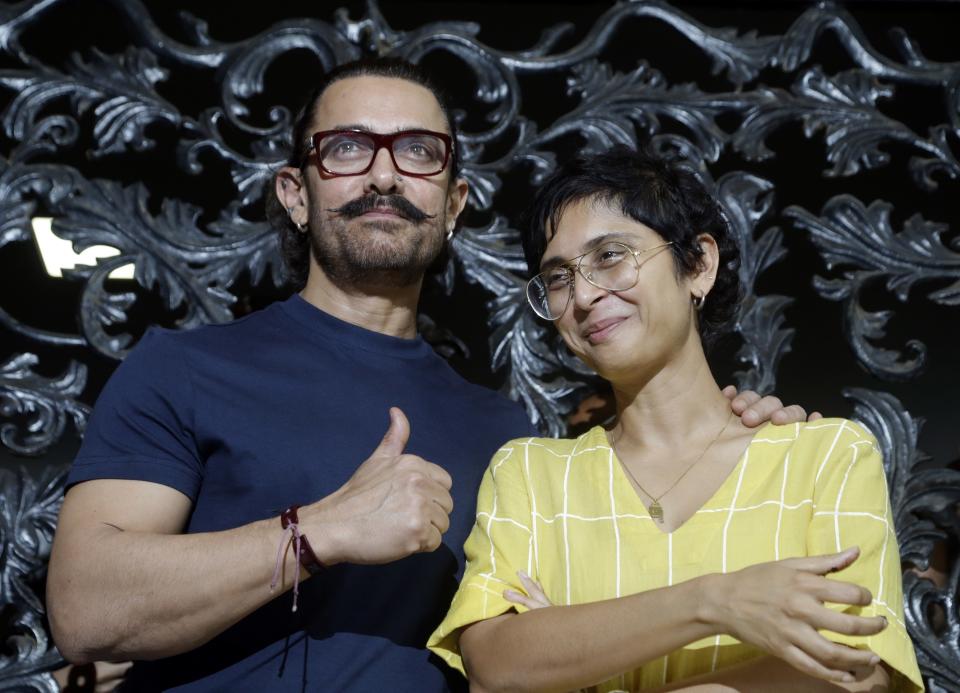 FILE - In this March 14, 2018 file photo, Bollywood actor Aamir Khan stands wife his wife Kiran Rao at their residence in Mumbai, India. On October 10, actor and heavyweight Bollywood producer Aamir Khan and his wife Kiran Rao put out a statement saying that they were “committed to doing any and everything to make our film industry a safe and happy one to work in.” In a Tweet, Khan said they were about to begin work with someone who has been accused of sexual misconduct and the matter is pending in court. (AP Photo/Rajanish Kakade, File)