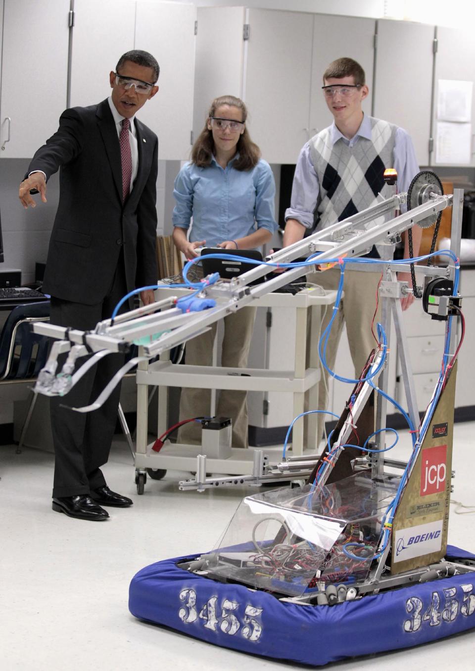 FILE - In this Sept. 16, 2011 file photo, President Barack Obama, with students Meghan Clark, center, and Nathan Hughes, right, watches as they demonstrate their FIRST Robot, during a visits to a classroom at Thomas Jefferson High School for Science and Technology in Alexandria, Va. America's decision to re-elect President Barack Obama over Republican presidential candidate, former Massachusetts Gov. Mitt Romney will impact key sectors of the American economy. During the President's first term, Obama signed into law the America Invents Act to streamline the U.S. patent process. The idea was that inventors and entrepreneurs could turn their ideas into products more quickly and create inexpensive ways to resolve disputes(AP Photo/Pablo Martinez Monsivais, File)