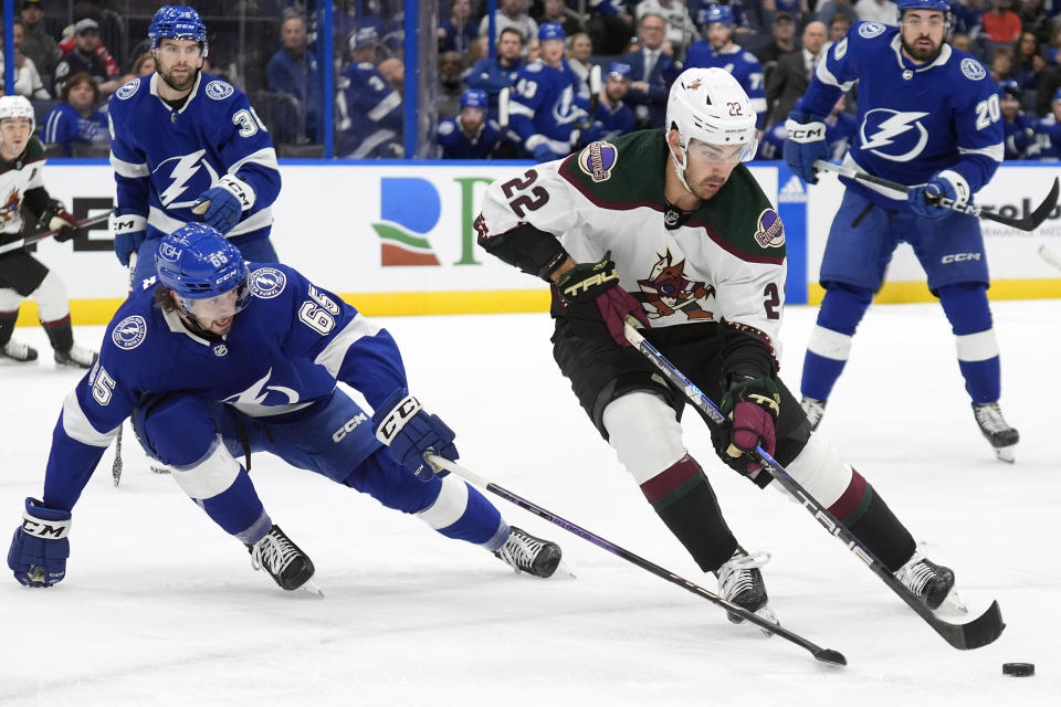 Arizona Coyotes center Jack McBain (22) works the puck around Tampa Bay Lightning defenseman Maxwell Crozier (65) during the first period of an NHL hockey game Thursday, Jan. 25, 2024, in Tampa, Fla. (AP Photo/Chris O'Meara)