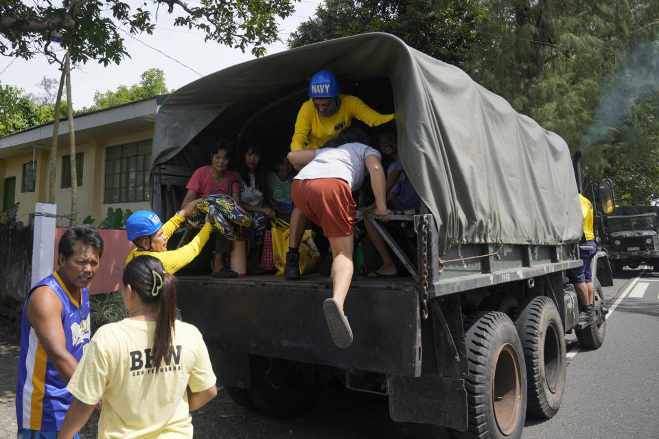 Villagers ride a military truck as they evacuate their homes in Santo Domingo town, Albay province, northeastern Philippines, Tuesday, June 13, 2023. Truckloads of villagers on Tuesday fled from Philippine communities close to gently erupting Mayon volcano, traumatized by the sight of red-hot lava flowing down its crater and sporadic blasts of ash. (AP Photo/Aaron Favila)