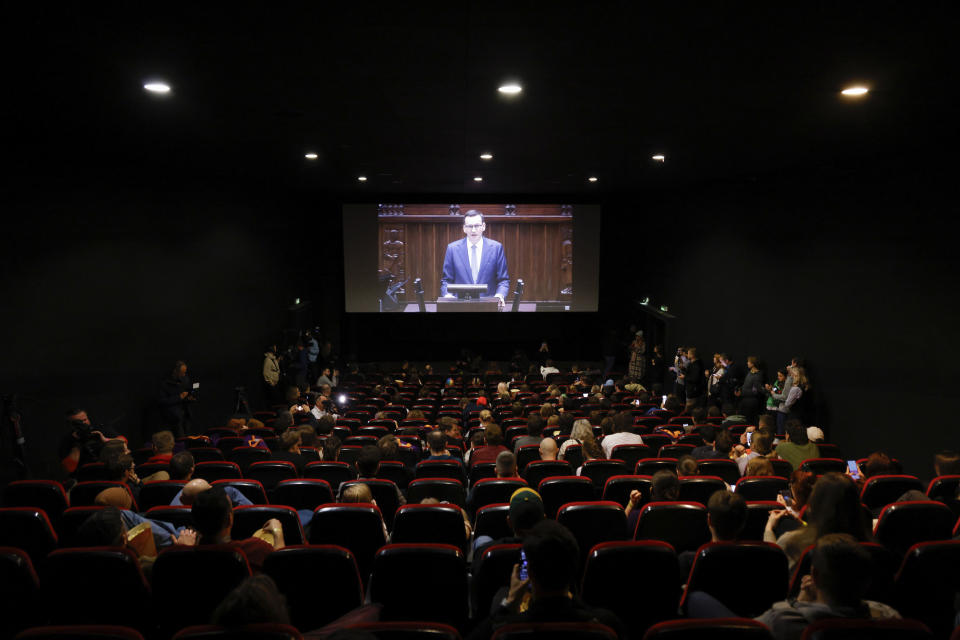 People fill a movie theatre to watch a speech to parliament by outgoing Polish Prime Minister Mateusz Morawiecki in Warsaw, Poland, Monday, Dec. 11, 2023. A movie theater in Warsaw is offering screenings of live proceedings in parliament, which have aroused huge interest in Poland as the country transitions from a conservative right-wing government to a centrist government. (AP Photo/Michal Dyjuk)