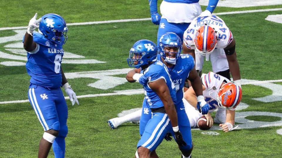 Kentucky Wildcats linebacker J.J. Weaver (13), center, celebrates with Kentucky Wildcats defensive lineman Josaih Hayes (97), right, and Kentucky Wildcats defensive lineman Octavious Oxendine (8) after Weaver sacked Florida Gators quarterback Graham Mertz (15) during a football game against Florida at Kroger Field in Lexington, Ky., Saturday, Sept. 30, 2023.