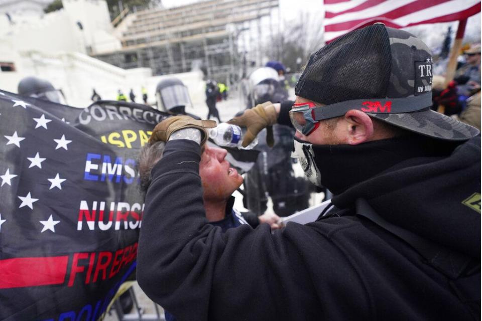 A demonstrator has his eyes flushed with water after confronting police, Wednesday, Jan. 6, 2021, at the Capitol in Washington. As Congress prepares to affirm President-elect Joe Biden's victory, thousands of people have gathered to show their support for President Donald Trump and his claims of election fraud. (AP Photo/Julio Cortez)