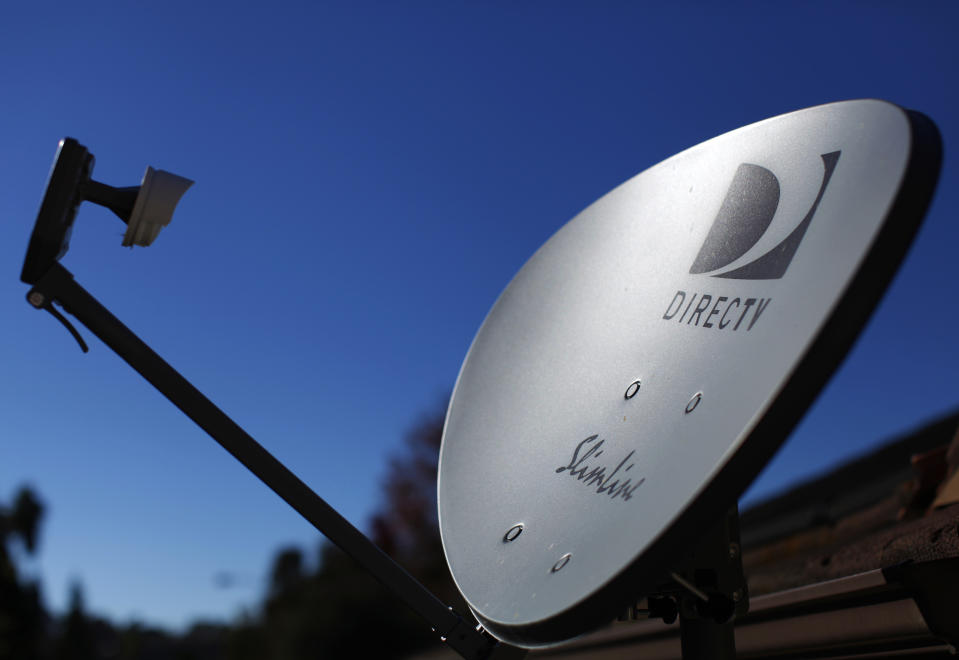 A DirecTV satellite dish is seen on a residential home in Encinitas, California November 5, 2014. Satellite TV provider DirecTV will report its third-quarter earnings Thursday.    REUTERS/Mike Blake (UNITED STATES - Tags: ENTERTAINMENT BUSINESS TELECOMS)