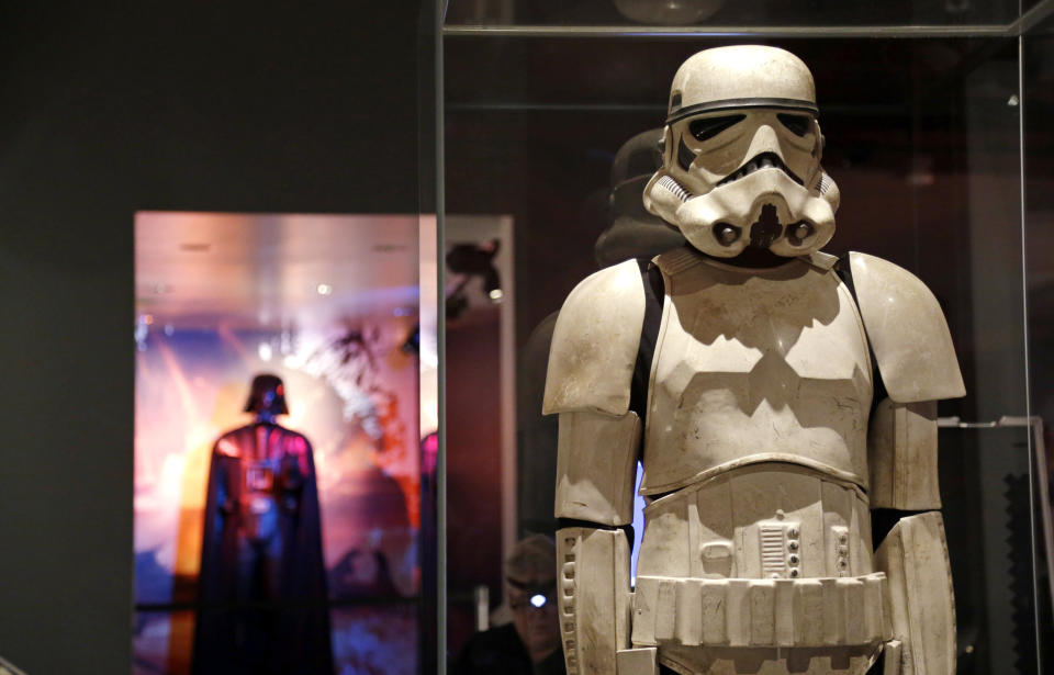 A stormtrooper costume is displayed with Darth Vader behind. (AP Photo/Elaine Thompson)