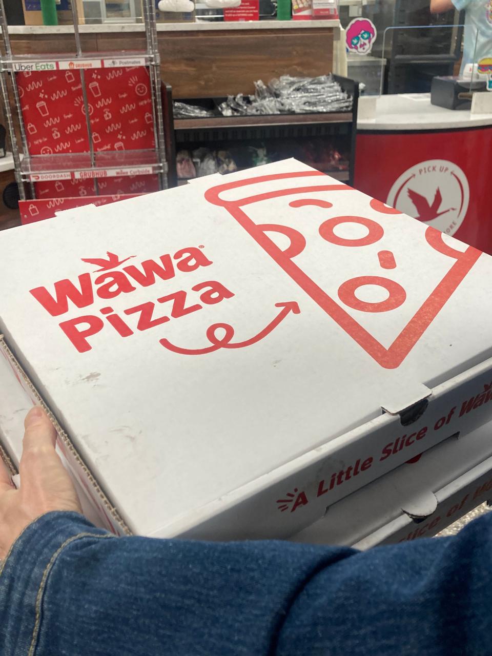 A customer carries two Wawa pizzas from a store at Haddonfield Road and Graham Avenue in Cherry Hill.