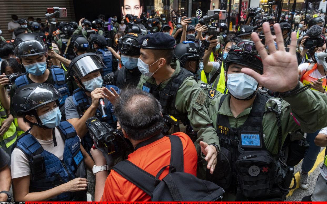 HONG KONG, CHINA - OCTOBER 01: A member of the press argues with the police during a banned protest in Hong Kong, China, on October 1, 2020. Police deployed 6,000 officers during 71st China's National Day anniversary to counter any illegal protests and assemblies in Hong Kong. (Photo by Miguel Candela Poblacion/Anadolu Agency via Getty Images) - Anadolu Agency