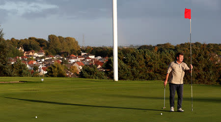 A golfer removes the flag stick at Sandhills golf club in Glasgow East, in Glasgow, Scotland, September 29, 2017. Photograph taken on September 29, 2017. REUTERS/Russell Cheyne