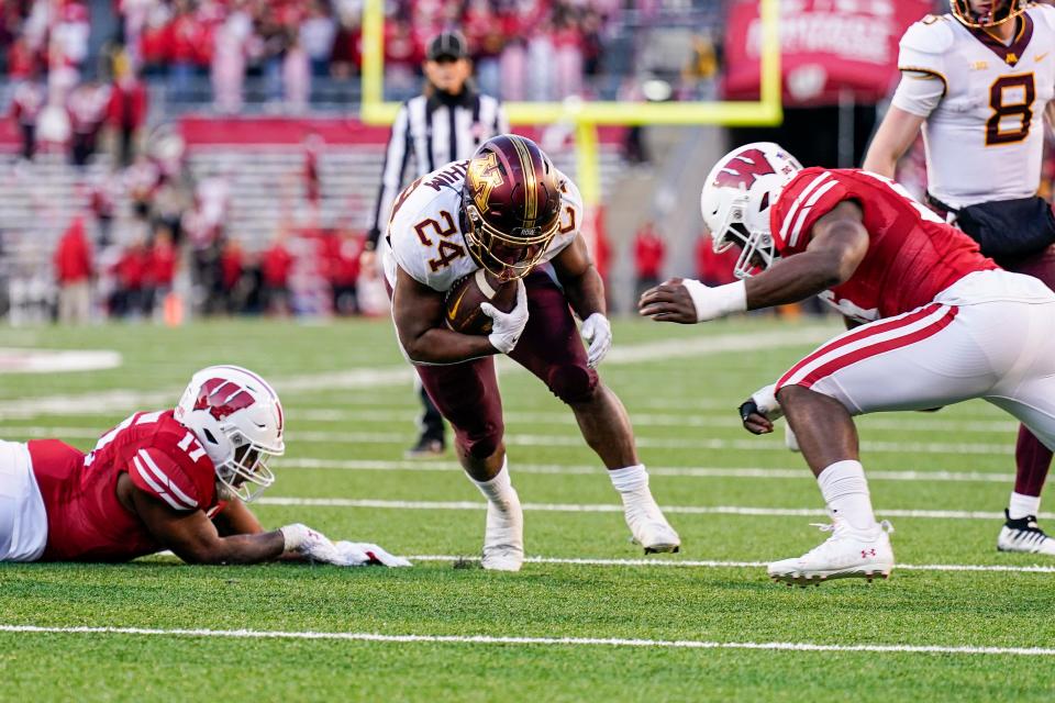 Minnesota running back Mohamed Ibrahim (24) runs between Wisconsin linebackers Darryl Peterson (17) and Maema Njongmeta, right, during the first half of an NCAA college football game Saturday, Nov. 26, 2022, in Madison, Wis. (AP Photo/Andy Manis)