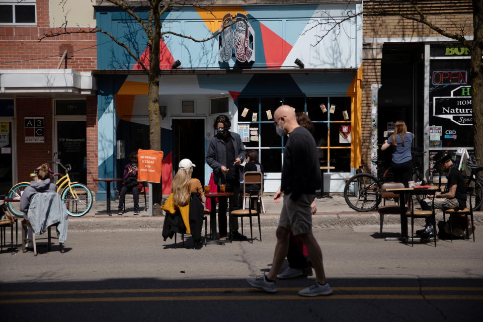 People walk as outdoor dining crowds outside of restaurants as coronavirus disease (COVID-19) restrictions are eased in Ann Arbor, Michigan, U.S., April 4, 2021.  REUTERS/Emily Elconin