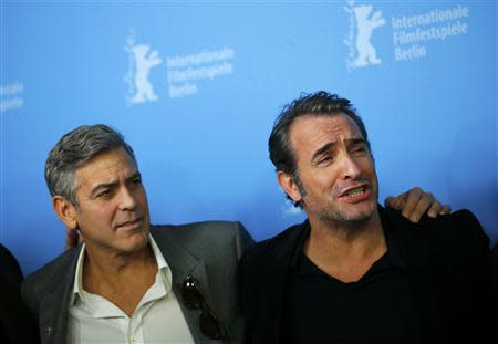 Director and actor George Clooney and cast member Jean Dujardin (R) attend a photocall to promote the movie "The Monuments Men" during the 64th Berlinale International Film Festival in Berlin February 8, 2014. REUTERS/Thomas Peter
