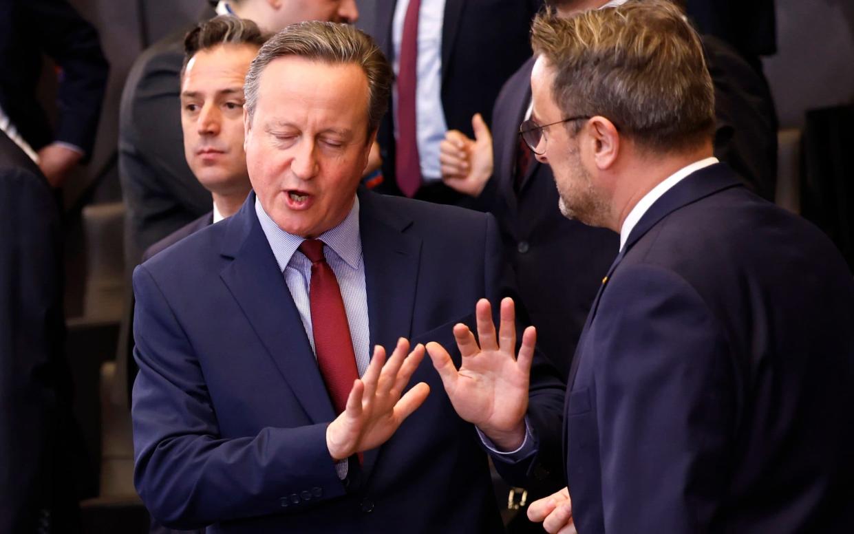 Lord Cameron, left, speaks with Luxembourg's Foreign Minister Xavier Bettel during a Nato summit in Brussels today