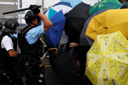 Police try to disperse protesters near a flag raising ceremony for the anniversary of Hong Kong handover to China in Hong Kong