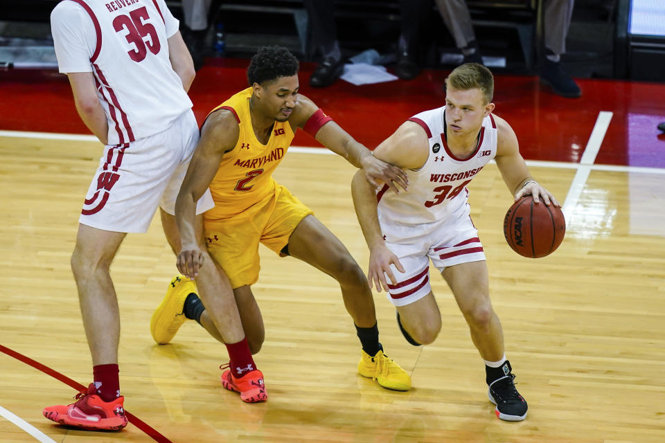 Wisconsin's Brad Davison (34) drives against Maryland's Aaron Wiggins (2) during the first half of an NCAA college basketball game Tuesday, Jan. 14, 2020, in Madison, Wis. (AP Photo/Andy Manis)