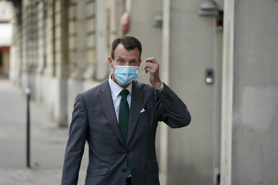 Denmark's Prince Joachim adjusts his face mask as he walks to work, at the Danish Embassy in Paris, France, Friday, Sept. 18 2020. Prince Joachim, the younger son of Queen Margrethe of Denmark, who underwent an emergency surgery in France in July for a blood clot in his brain, says he is “eager to get started” as he arrived for his first work day at the Danish Embassy in Paris. The 51-year-old prince spoke to reporters outside the Danish mission where he will be defense attache. Joachim was rushed to the Toulouse University Hospital on July 24. (Mads Claus Rasmussen/ Ritzau Scanpix via AP)