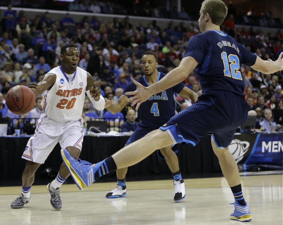 Florida guard Michael Frazier II (20) passes the ball against UCLA forward David Wear (12) during the first half in a regional semifinal game at the NCAA college basketball tournament, Thursday, March 27, 2014, in Memphis, Tenn. (AP Photo/Mark Humphrey)