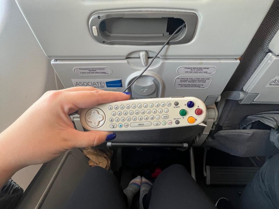 The author holding the remote, which stores in the seatback.