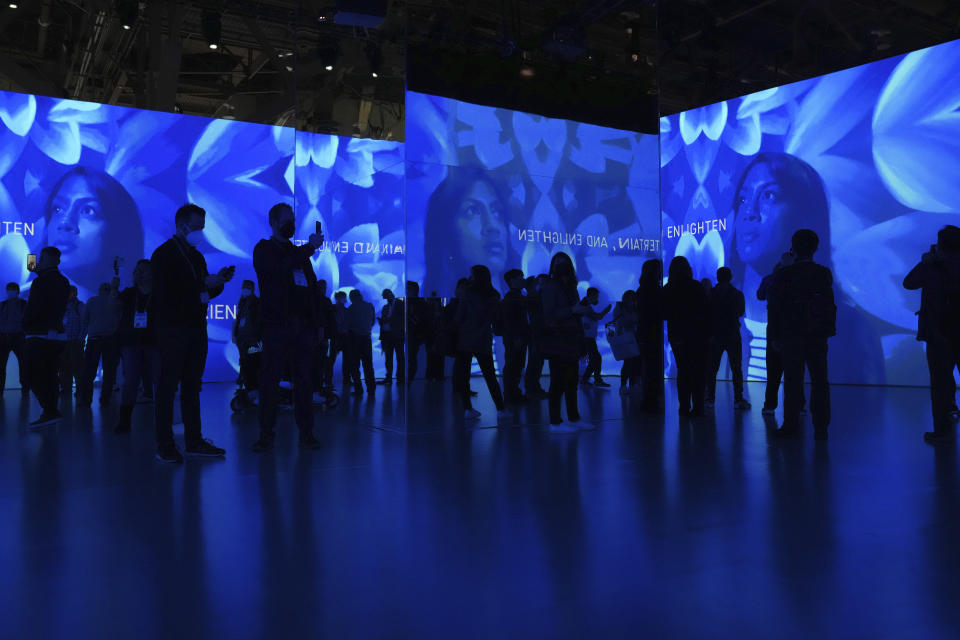 FILE - Attendees view projected images at an immersive entertainment theater exhibit at the Panasonic booth during the CES tech show, Wednesday, Jan. 5, 2022, in Las Vegas. The thousands of people who gathered in Las Vegas for this week's CES gadget show were a fraction of the usual crowd for the influential tech conference, the event's organizer said Friday, Jan. 7. The Consumer Technology Association said on the show's closing day that more than 40,000 people attended the multi-day event on the Las Vegas Strip. (AP Photo/Joe Buglewicz, File)