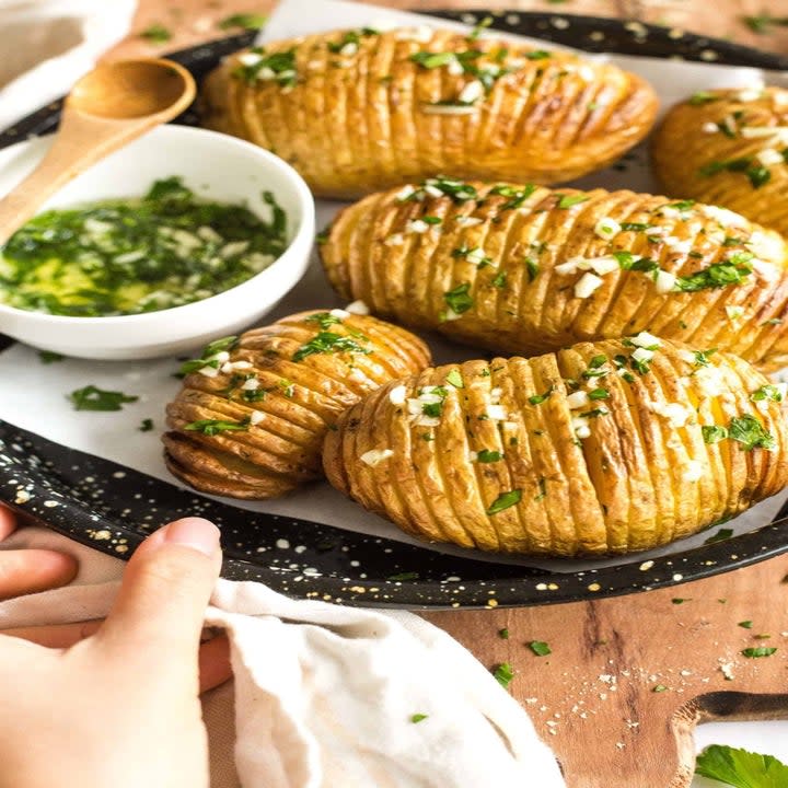 Hasselback potatoes with green herb sauce.