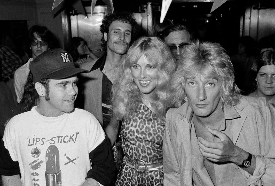 Elton John, left, Alana Hamilton, wife of actor George Hamilton, and rock singer Rod Stewart arrive at Studio 54, July 10, 1978, to celebrate at a party given by RCA Records.