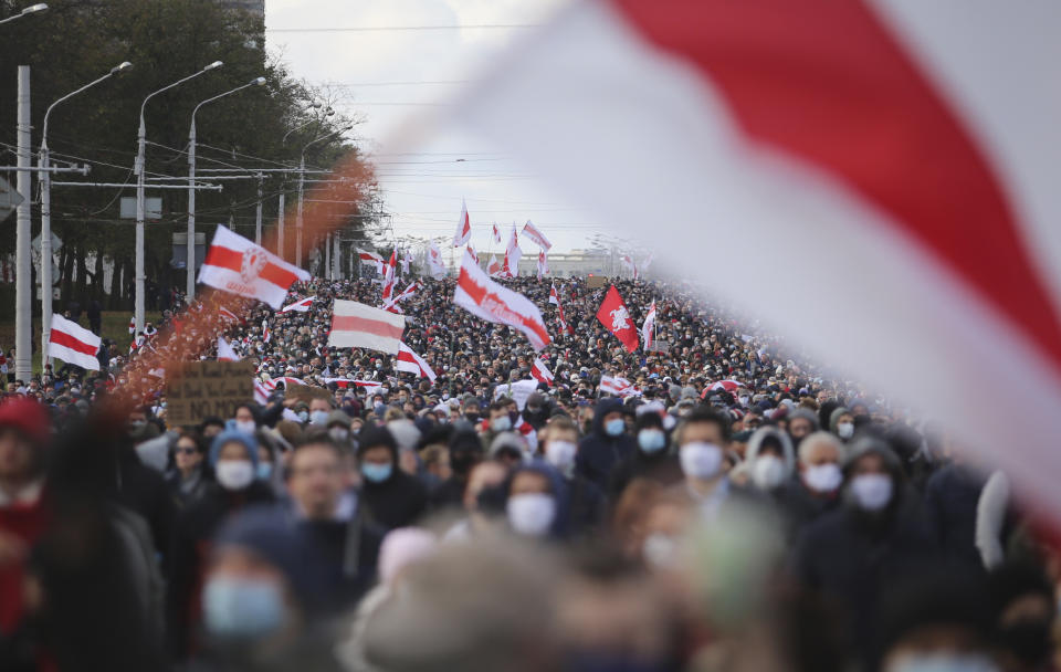 People with old Belarusian national flags march during an opposition rally to protest the official presidential election results in Minsk, Belarus, Sunday, Oct. 18, 2020. Tens of thousands rallied in Minsk once again on Sunday, demanding the resignation of the country's authoritarian leader. Mass weekend protests in the Belarusian capital have continued since Aug. 9, when officials handed President Alexander Lukashenko a landslide victory in an election widely seen as rigged. (AP Photo)