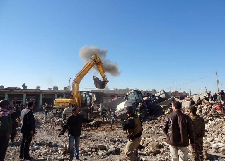 Local men inspect the site of an explosion in Kirkuk, Iraq, on January 16, 2013. Attacks in Baghdad and north Iraq killed 42 people on Wednesday as hundreds attended the funeral of a Sunni MP who died in a suicide attack a day earlier, as a political crisis grips the country