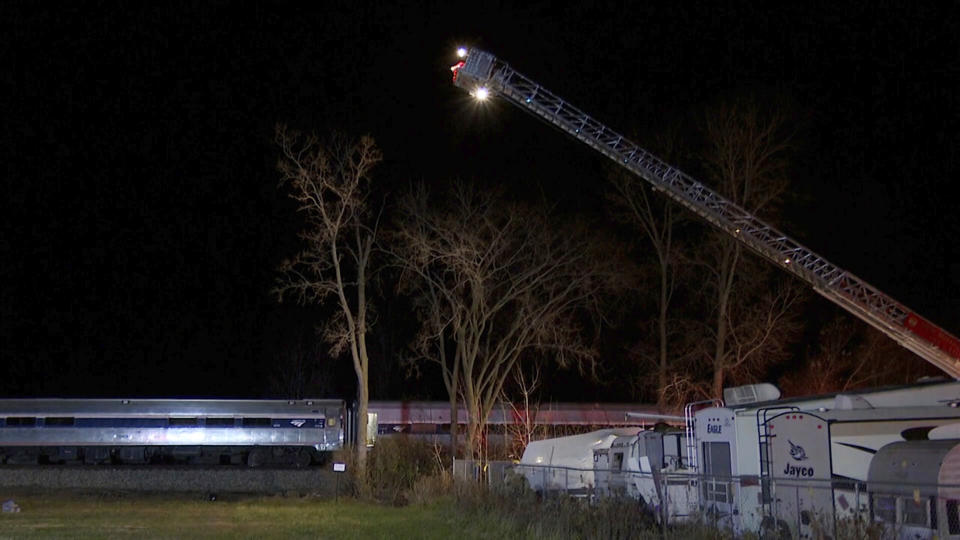 Emergency personnel respond to an Amtrak train after derailing on Thursday, Nov. 16, 2023 near New Buffalo, Mich. Authorities say 11 people were injured when the train heading to Chicago derailed in southwestern Michigan. The train derailed Thursday night after hitting an empty vehicle. The train went off the tracks but remained upright. (WBND via AP)