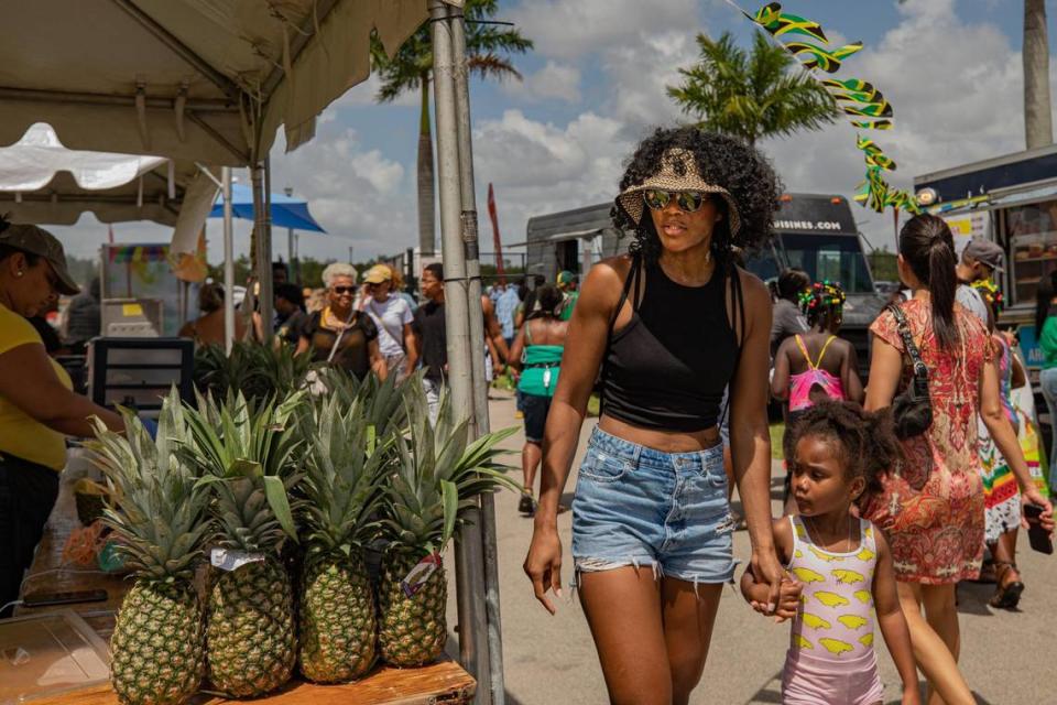 Rebeka Brown (left) walks past a vendor with her daughter Maari Smart, 4, during the Jamaica Emancipendence Ole Time Fair at Miramar Regional Park Amphitheater in Miramar, Florida on Saturday, August 6, 2022. The free family-friendly event included kids trampolines, farmers market and dancing in celebration of Jamaica’s 60th Independence Anniversary.