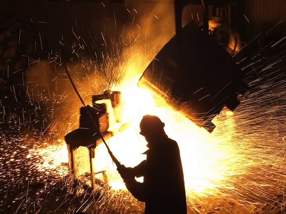 A steel worker operating equipment in a foundry.