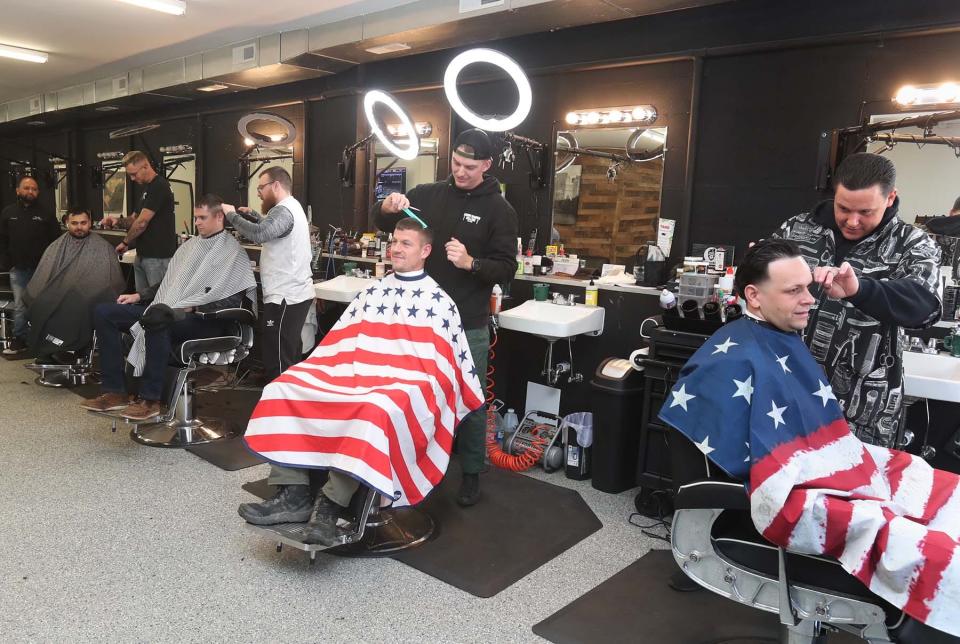 Bell's Barbershop, owned by Justin Bell, standing right, is busy at its new location in Stow.