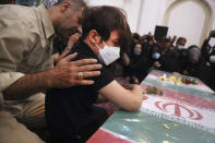 Son of Iran's Revolutionary Guard Col. Hassan Sayyad Khodaei who was killed on Sunday weeps over his flag draped coffin during his funeral in Tehran, Iran, Tuesday, May 24, 2022. Iran's hard-line President Ebrahim Raisi vowed revenge on Monday over the killing of Sayyad Khodaei who was shot at his car by two assailants outside his home in Tehran, a still-mysterious attack on the country's powerful paramilitary force. (AP Photo/Vahid Salemi)