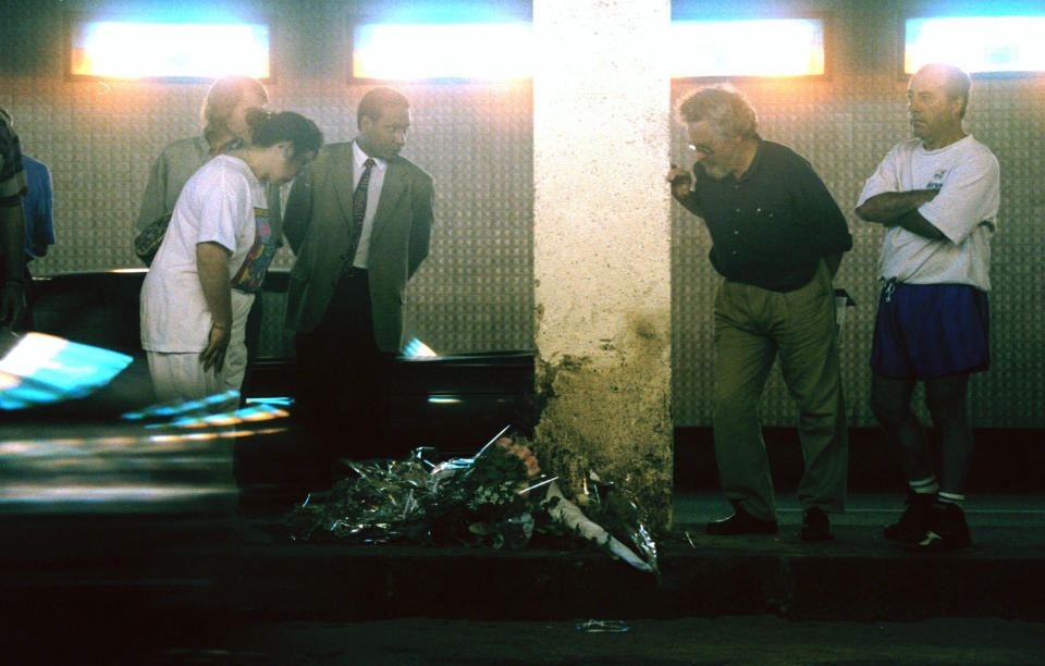 FILE - With flowers placed on the ground, mourners stand around the 13th support pole in the Alma Bridge tunnel in Paris, Aug. 31, 1997, the place where Princess Diana and her companion Dodi Fayed died in a car crash early Sunday. The story of Princess Diana's death at age 36 in that catastrophic crash in a Paris traffic tunnel continues to shock, even a quarter-century later. (AP Photo/Jerome Delay, File)