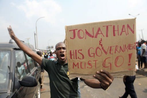 A man carries placard reading, "Jonathan And His Government Must Go!" at Gani Fawehinmi Park in Lagos. Tens of thousands of protesting Nigerians defied an order to end a three-day-old strike Wednesday as unions threatened oil production and a mob rampaged in one city, leaving a police officer dead