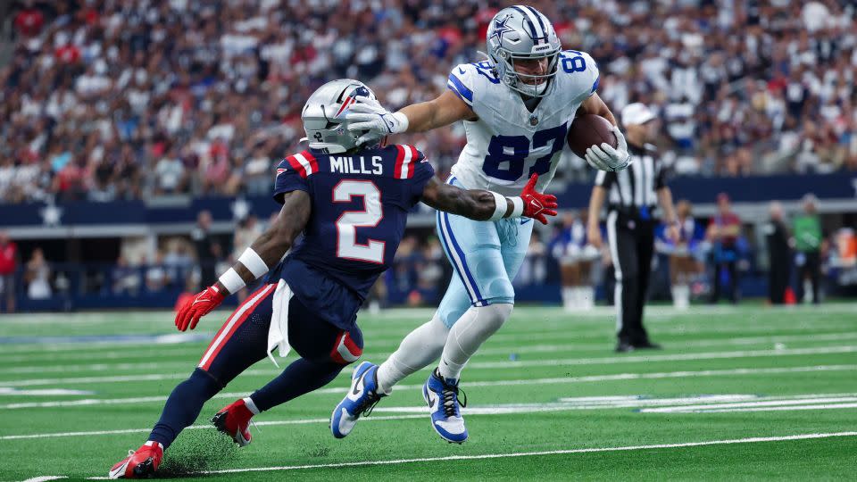 Dallas Cowboys tight end Jake Ferguson (87) runs with the ball as New England Patriots cornerback Jalen Mills (2) defends. - Kevin Jairaj/USA Today Network/Reuters