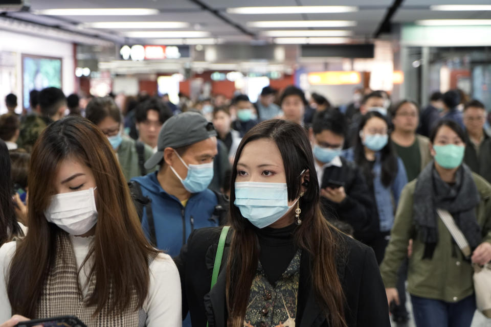 Passengers wear masks to prevent an outbreak of a new coronavirus in a subway station, in Hong Kong, Wednesday, Jan. 22, 2020. The first case of coronavirus in Macao was confirmed on Wednesday, according to state broadcaster CCTV. The infected person, a 52-year-old woman, was a traveller from Wuhan. (AP Photo/Kin Cheung)