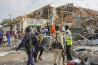 Security forces and rescue workers search for bodies at the scene of a blast in Mogadishu, Somalia Thursday, Nov. 25, 2021. Witnesses say a large explosion has occurred in a busy part of Somalia's capital during the morning rush hour. (AP Photo/Farah Abdi Warsameh)