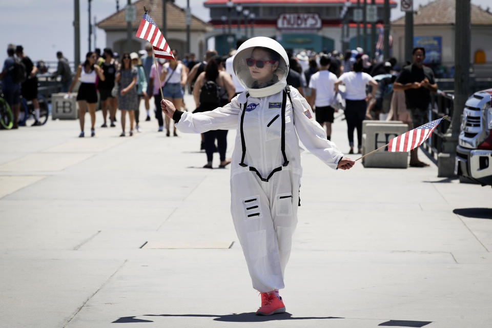 A visitor wears a space suit costume on the pier Saturday, June 27, 2020, in Huntington Beach, Calif. (AP Photo/Marcio Jose Sanchez)