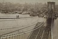 <p>Two men stand on the catwalk of the almost completed Brooklyn Bridge in 1880. With just the motorway to finish, the bridge was opened three years later. </p>