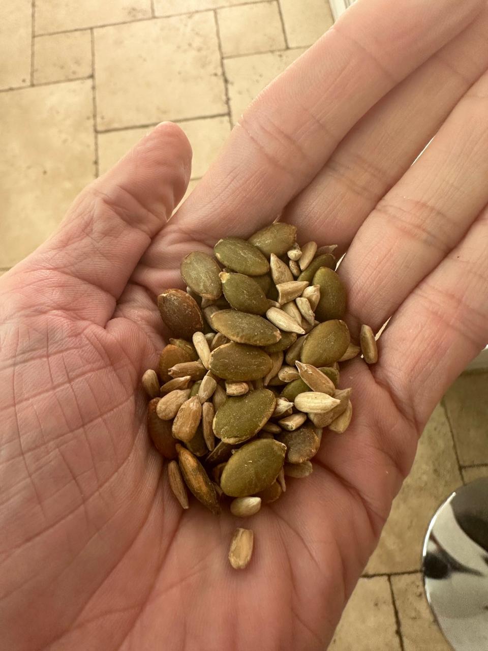 tina holding handful of seeds, including pumpkin and sunflower