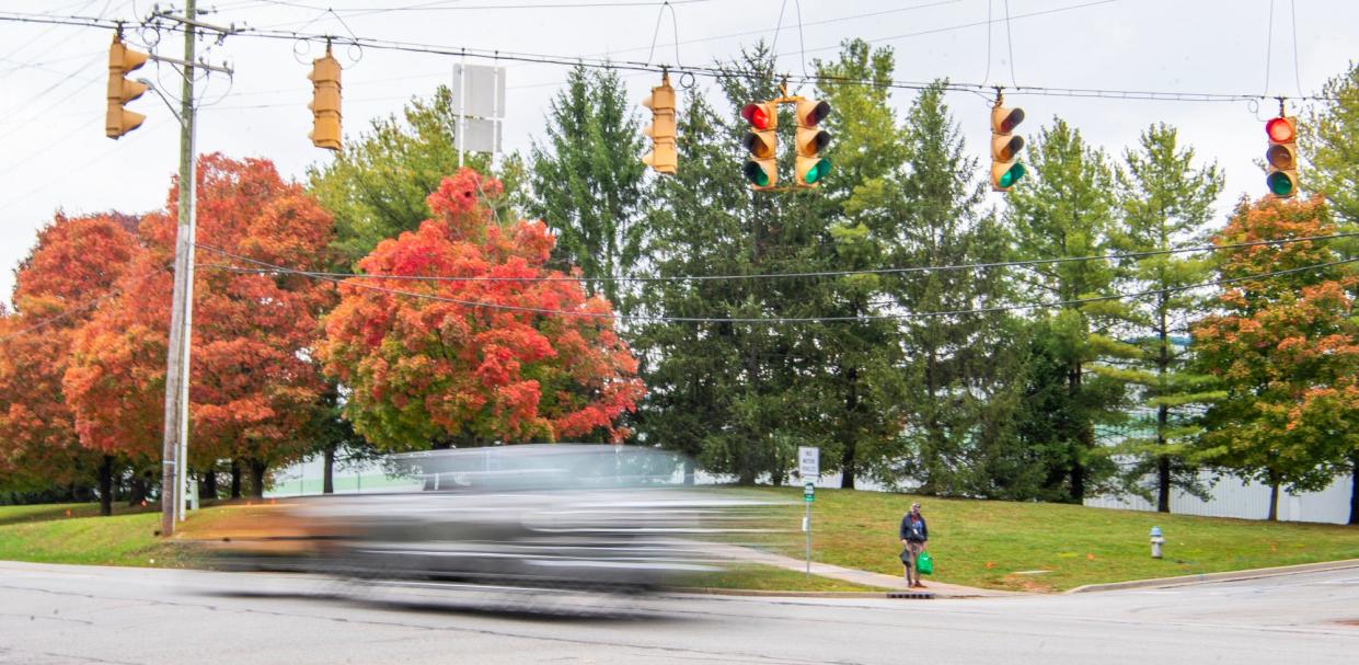 A man waits for a bus at the corner of Discovery Parkway and 10th Street on Tuesday, Oct. 17, 2023.